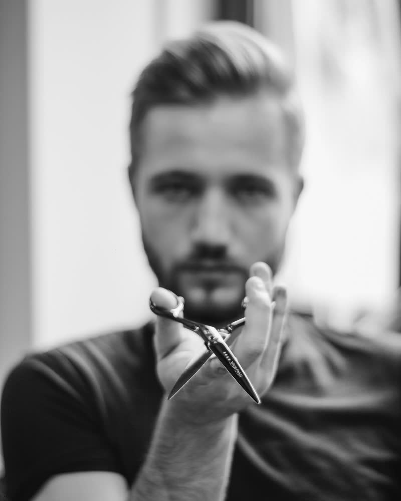 Jonas hält eine Friseurschere in die Kamera